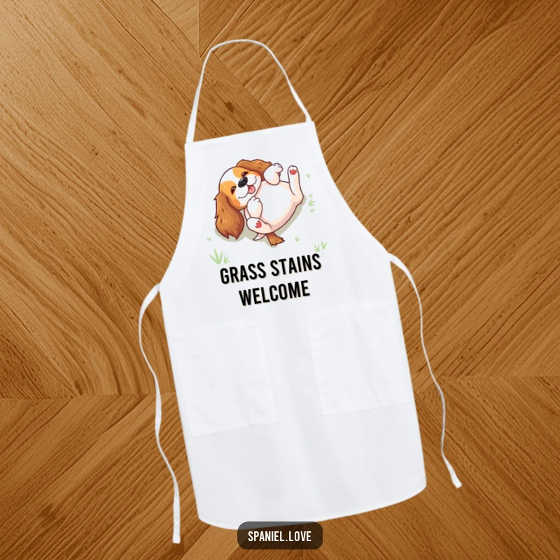 Funny spaniel rolling on its back in grass on an apron, a humorous kitchen accessory for joy-filled cooks.