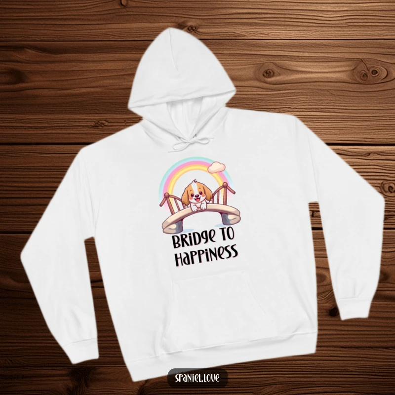 Funny hoodie illustrating a giddy spaniel character smiling while sliding down a bright rainbow bridge.