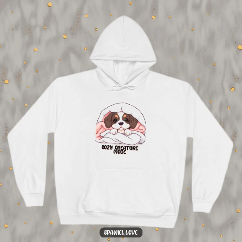 Funny hoodie featuring a spaniel puppy peeking from a pile of soft blankets, perfect for cozy comfort and smiles.