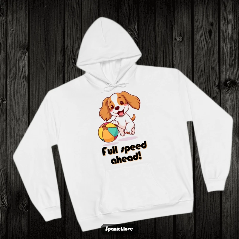 Funny hoodie showcasing a spaniel dog with its ears flapping jauntily as it joyfully pursues a brightly colored bouncing ball, full of energy.