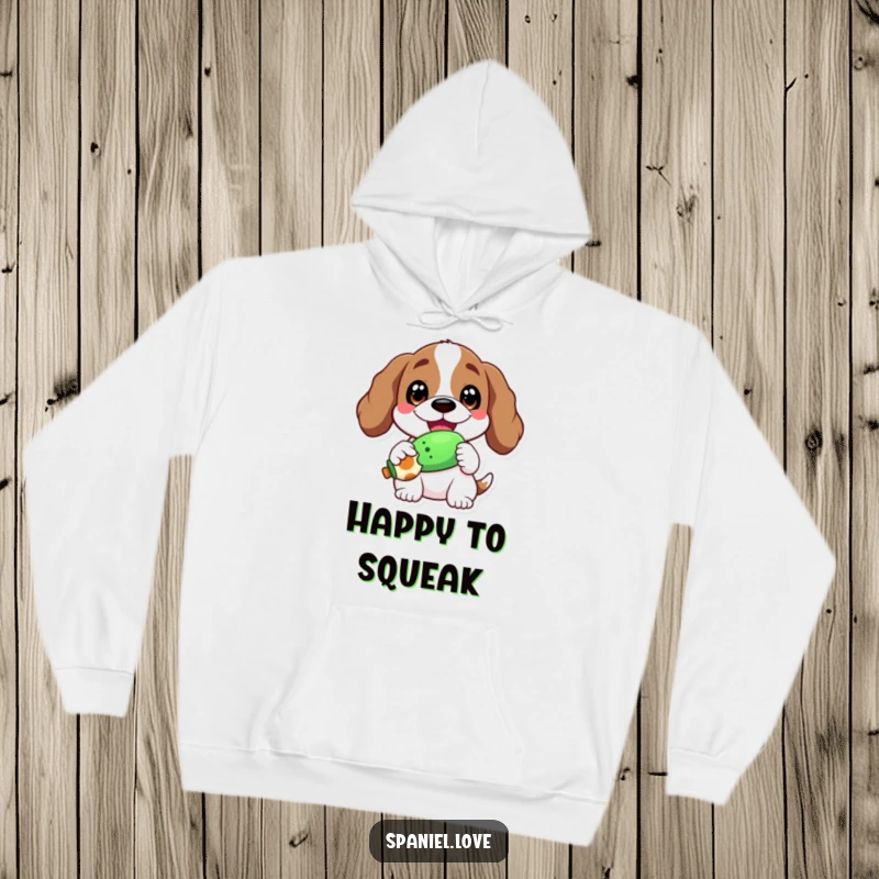 Funny hoodie depicting a spaniel with a wide, happy grin, proudly holding a squeaky toy, radiating pure delight.