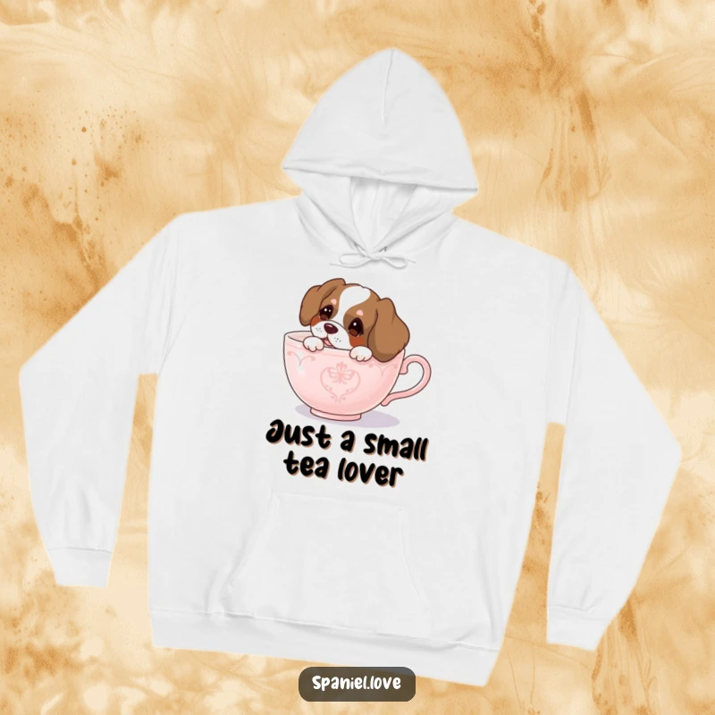 Funny spaniel hoodie, a curious dog peeking from a giant teacup, combining comfort with playful intrigue.