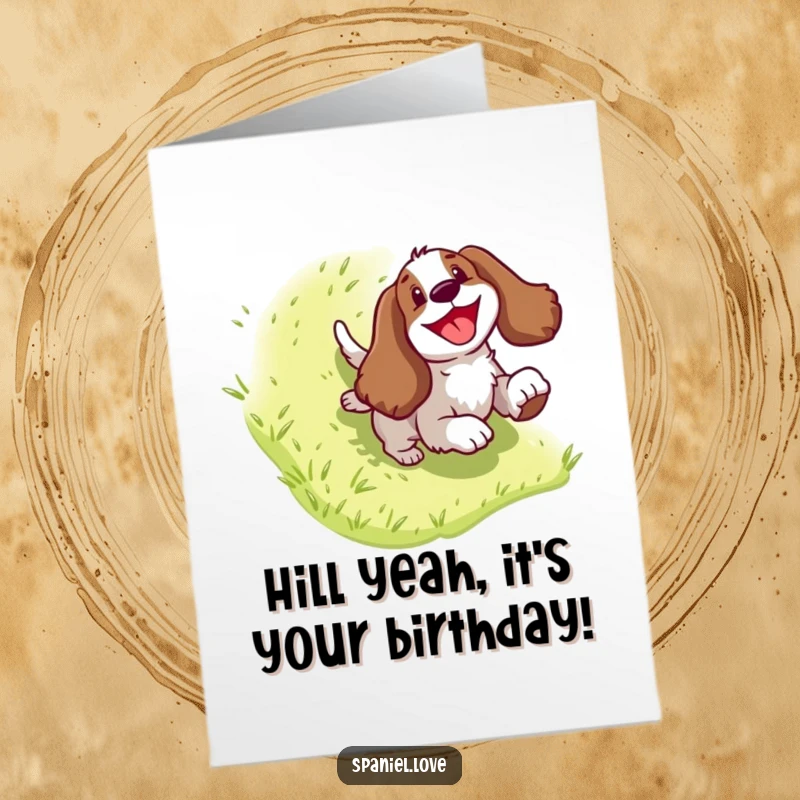 Funny Free Printable Birthday Card: Energetic Spaniel gleefully sliding down a green grassy hill, pure joy depicted.