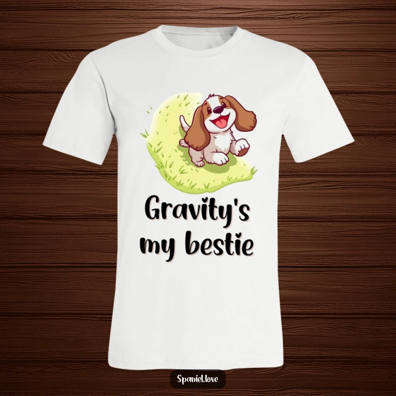 Funny Spaniel T-Shirt: Playful dog character joyfully sliding down a green hill, radiating happiness and a sense of adventure.