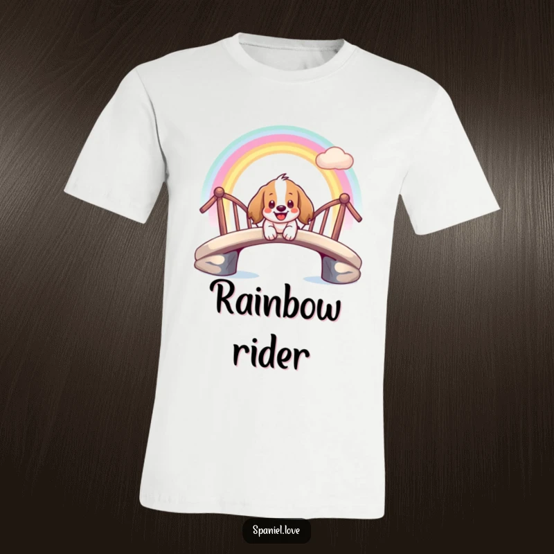 Funny t-shirt depicting a giddy spaniel character smiling as it slides down a colorful rainbow bridge.