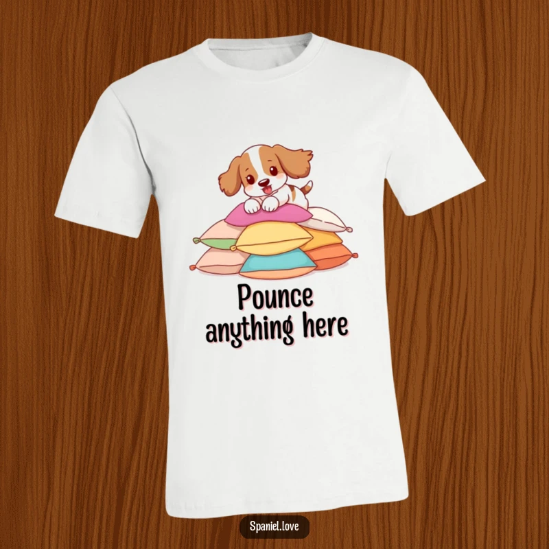 Funny Spaniel T-Shirt depicting a spaniel joyfully pouncing on a pile of pillows, ideal casual wear.